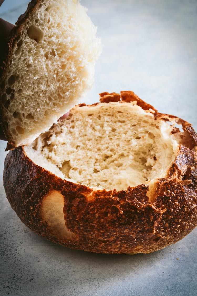 Sourdough round cut into a bread bowl for spinach dip