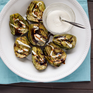 grilled baby artichokes drizzled with sauce and balsamic glaze