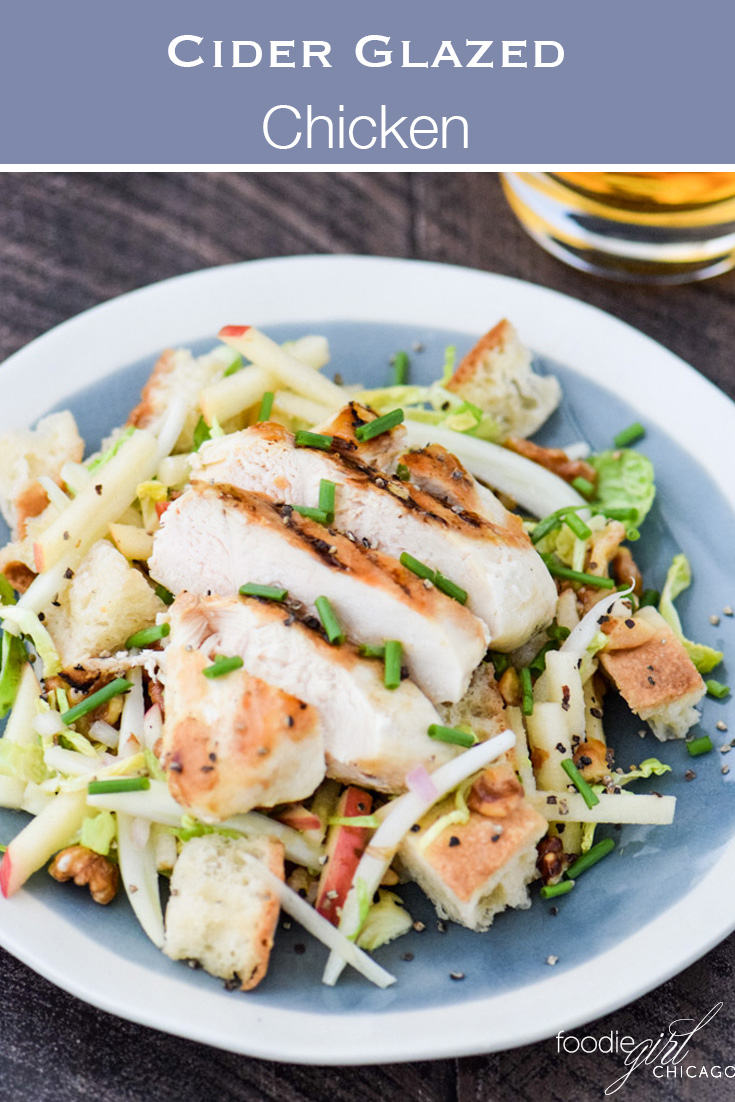 Cider glazed chicken on a bed of panzanella salad on a blue plate