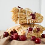 Two glazed Orange Cranberry Scones stacked and drizzled with glaze