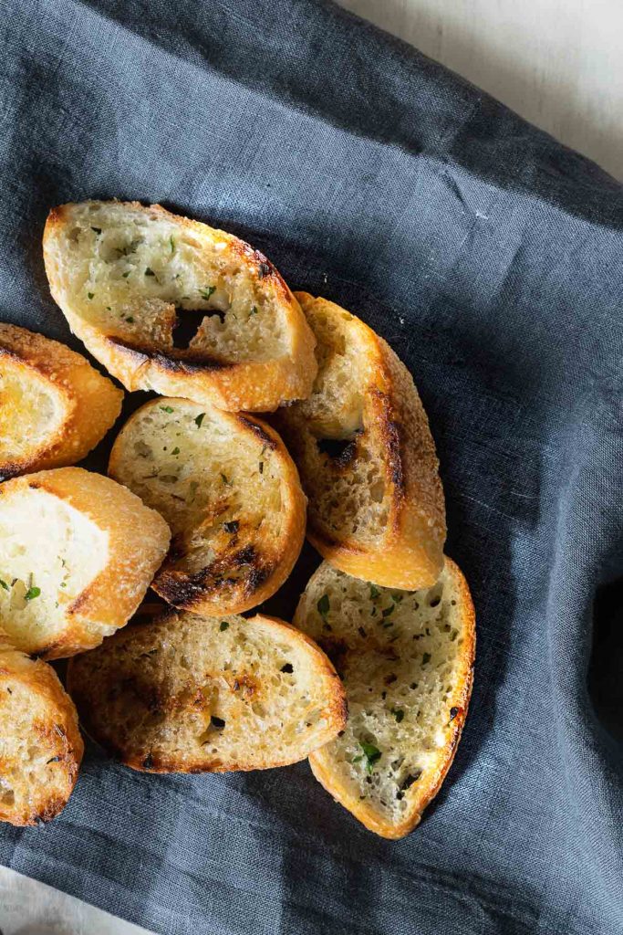 Slices of toasted baguette on a dark grey napkin