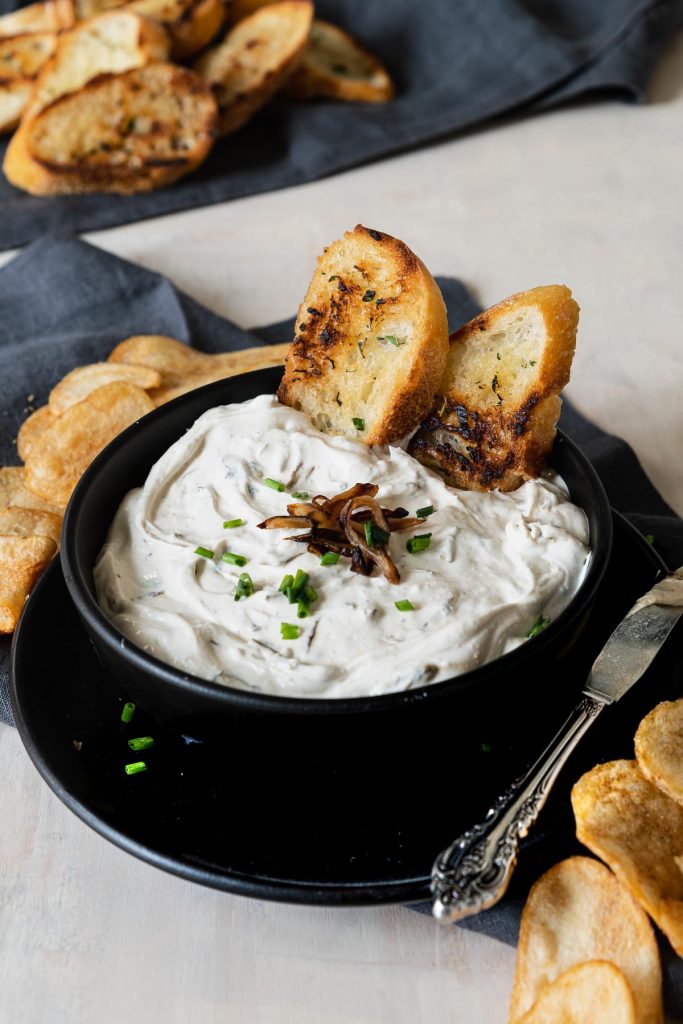 Black matte bowl filled with caramelized onion dip