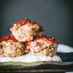 Three turkey meatloaf muffins on mashed potatoes