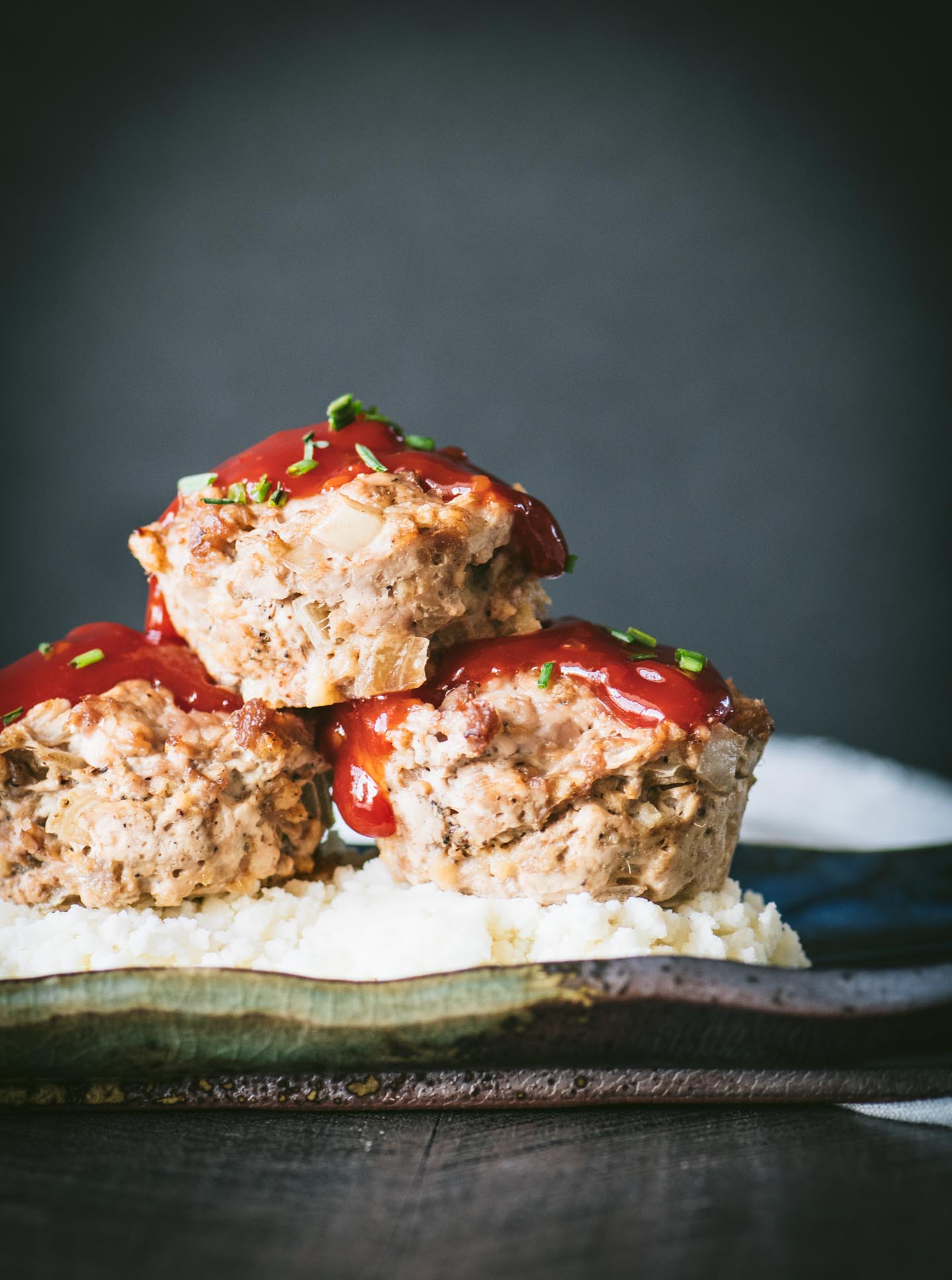 Three turkey meatloaf muffins on mashed potatoes