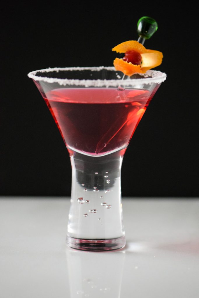 Cranberry Infused Vodka Martini in front of a black background