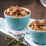 Two bowls of farro topped with chicken, pistachios and pomegranate
