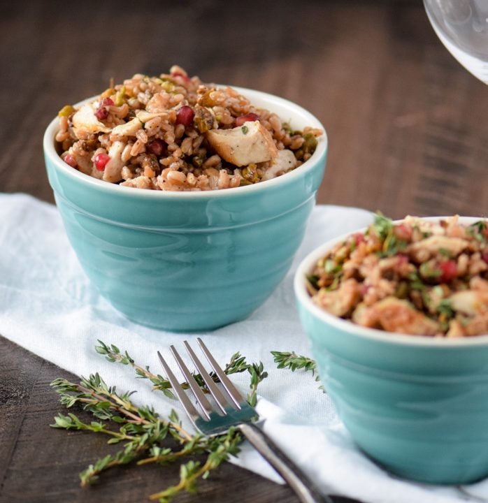 Two bowls of farro topped with chicken, pistachios and pomegranate