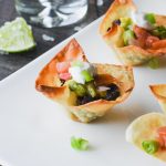 Mini wonton taco cups are filled with seasoned black bean, pico de gallo and guacamole
