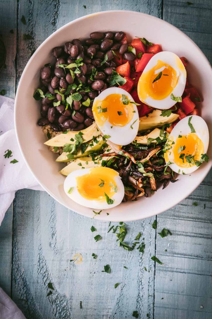 quinoa topped with avocados, black beans, caramelized onions and jammy eggs