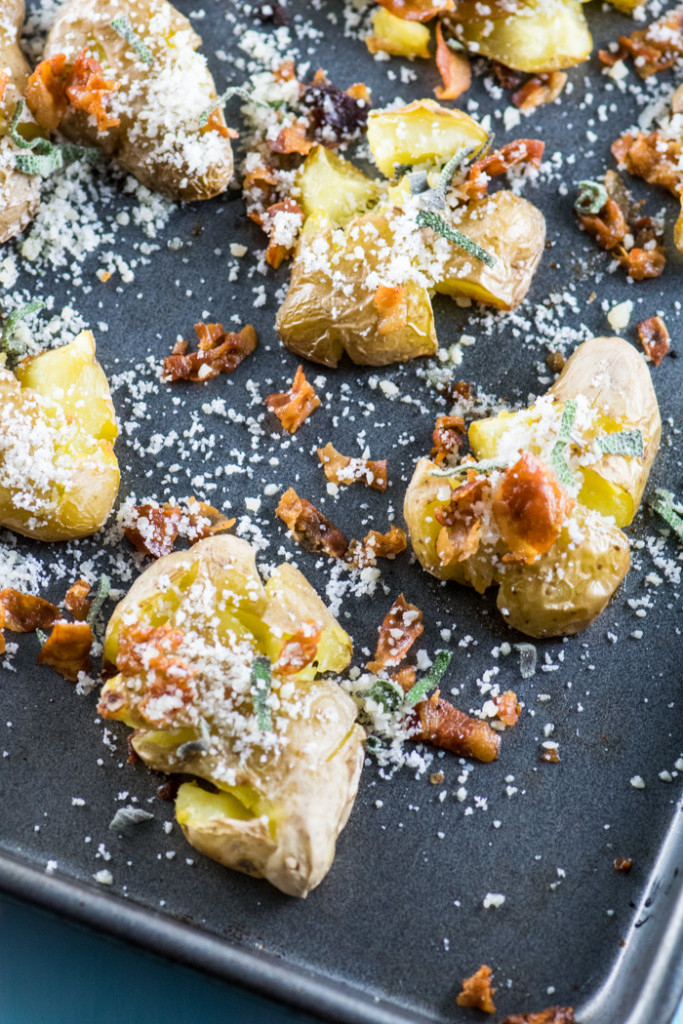 Smashed potatoes with pancetta and sage on a baking sheet