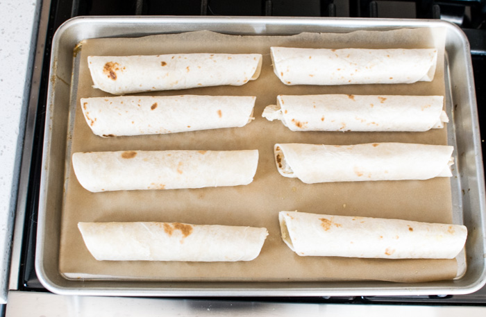 Baking tray with rolled tortillas filled with flauta filling