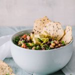 Healthy Cowboy Caviar in a light blue bowl with multigrain tortilla chips