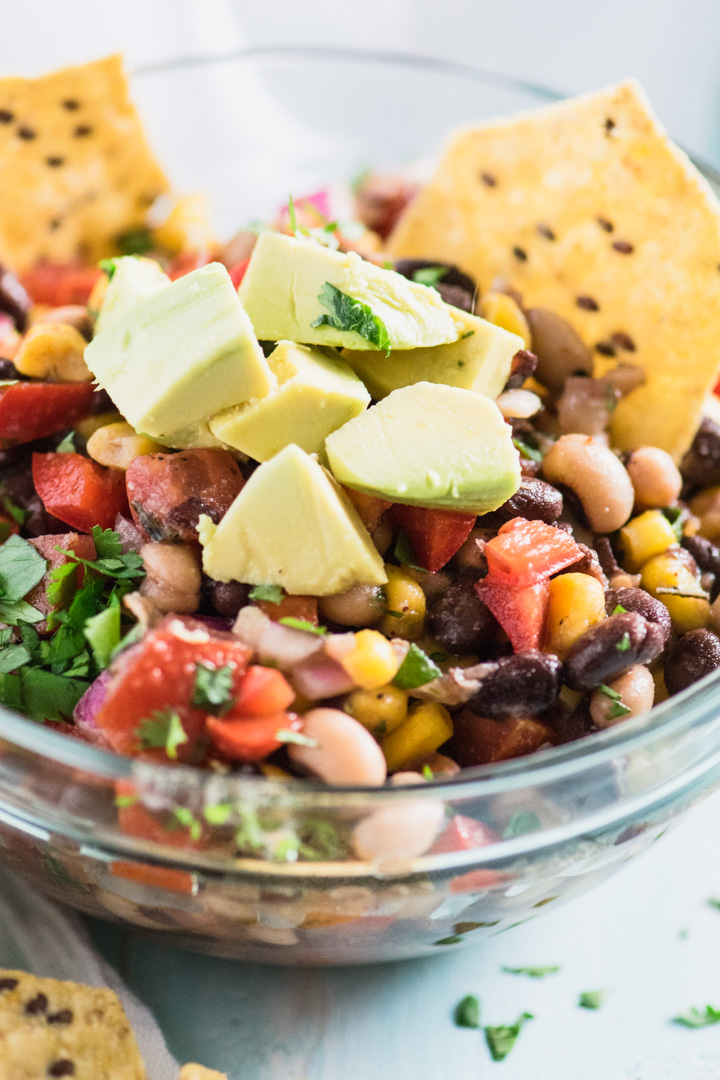 a bowl of Healthy Cowboy Caviar topped with chopped avocados