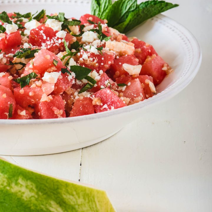 Watermelon salad topped with quinoa, feta and fresh mint leaves