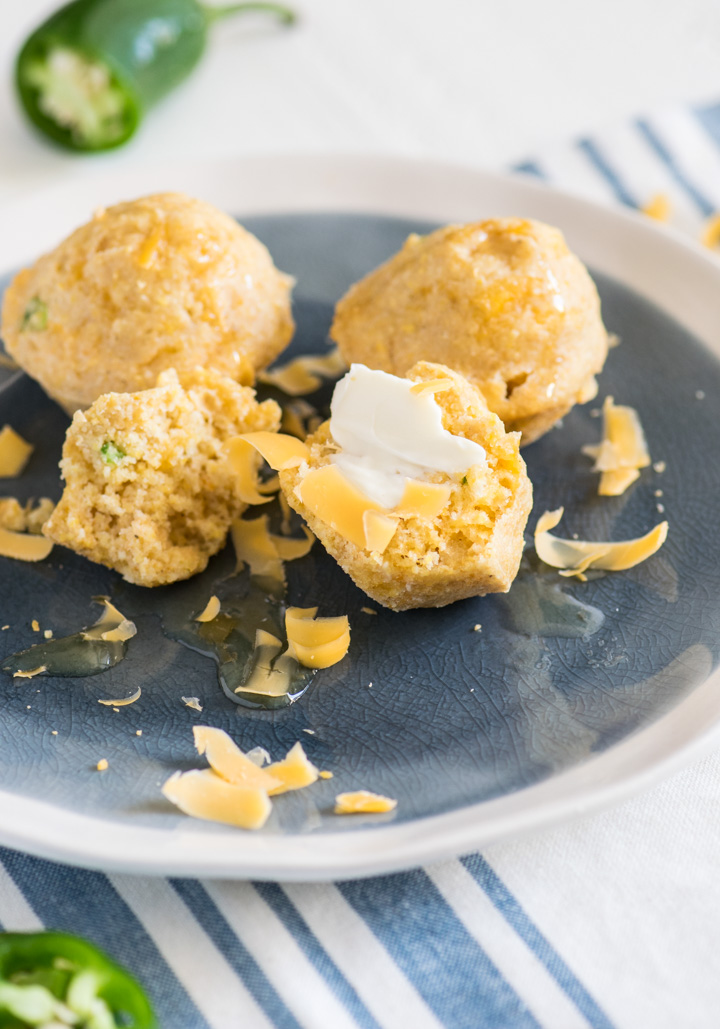 Three Jalapeño Cheddar Cornbread Bites on a light blue and white plate