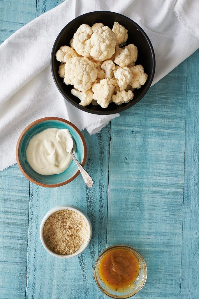 Bowl of cauliflower florets, and small bowls of other recipe ingredients