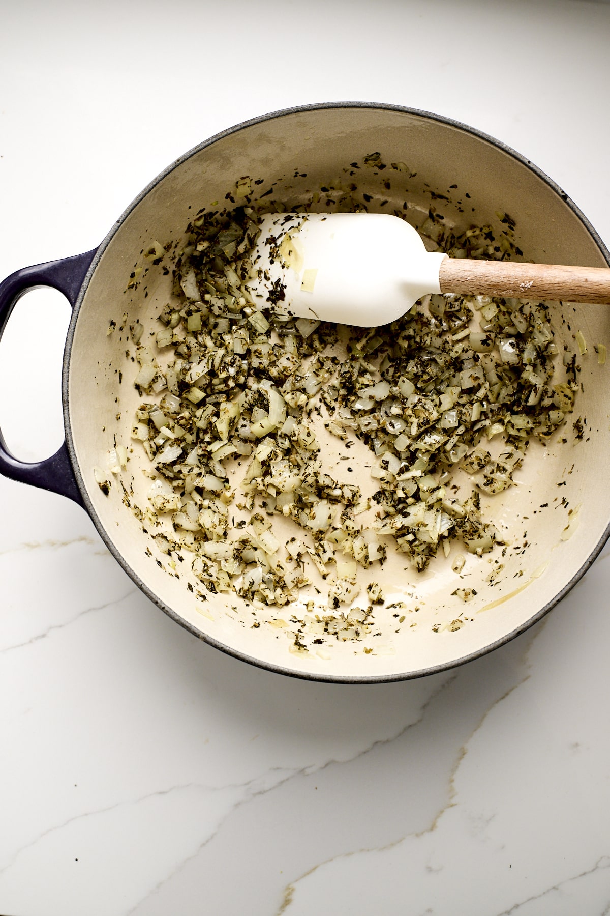 Onions and garlic, mixed with spices, cooking in a pan