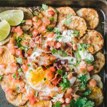 Nachos made with potato rounds topped with avocado crema and an egg