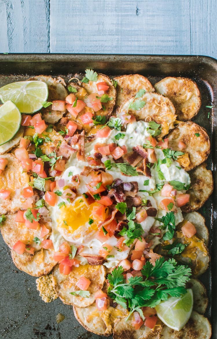 Nachos made with potato rounds topped with avocado crema and an egg