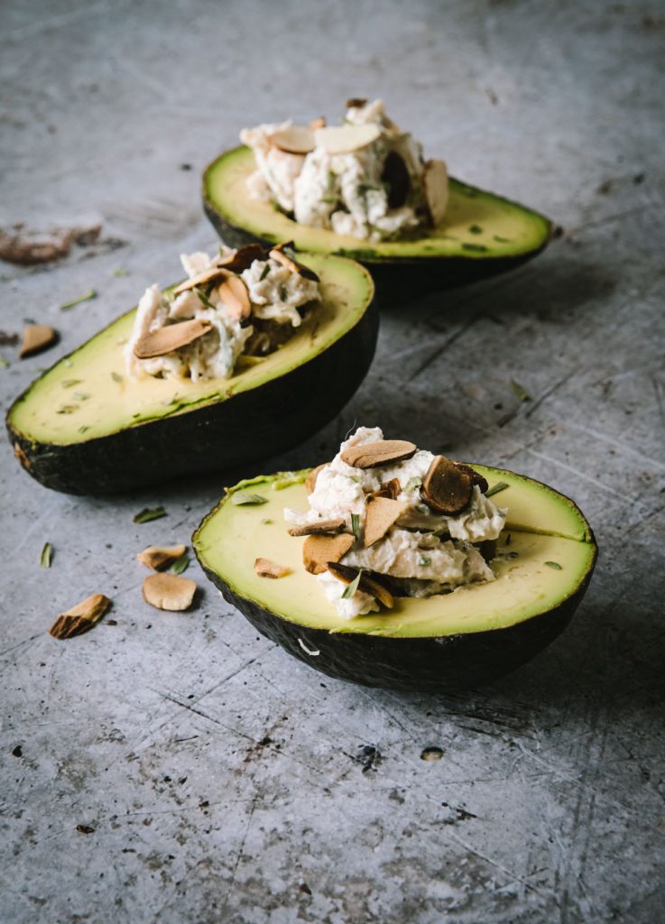 Side angle photo of three avocados stuffed with chicken salad