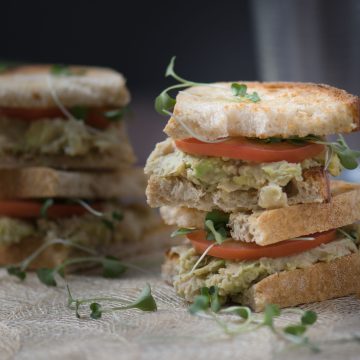 Vegetarian avocado & White bean sandwiches topped with roma tomato