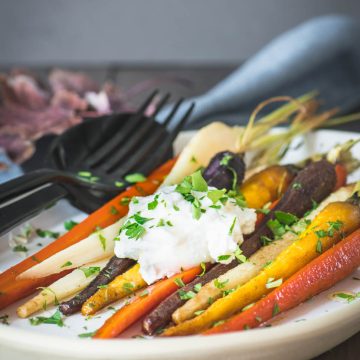 Tri-color roasted carrots on a cream plate