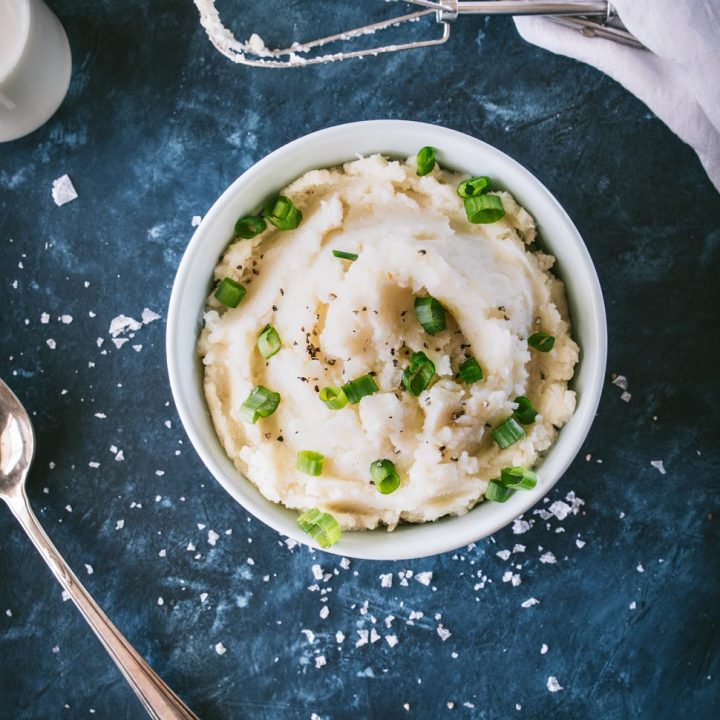Parmesan Cauliflower Mashed Potatoes in a bowl on a blue background shot from overhead