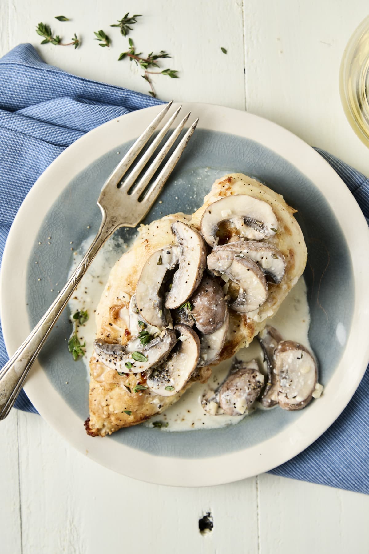 Breaded chicken breast topped with a creamy colored sauce with mushrooms