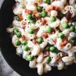 Cavatappi pasta with a lighter cheese sauce topped with green peas and pancetta