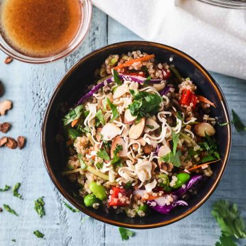 Asian quinoa salad with edamame, cabbage and red pepper in a dark blue bowl