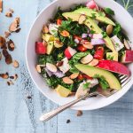 Chopped Kale Salad topped with bright veggies in an off-white bowl