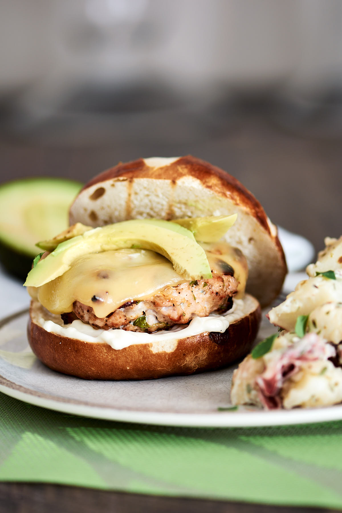 Turkey burger patty on a toasted bun topped with swiss cheese and avocado