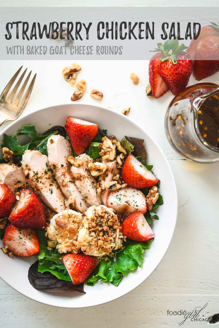 Salad topped with grilled chicken, strawberries and baked goat cheese