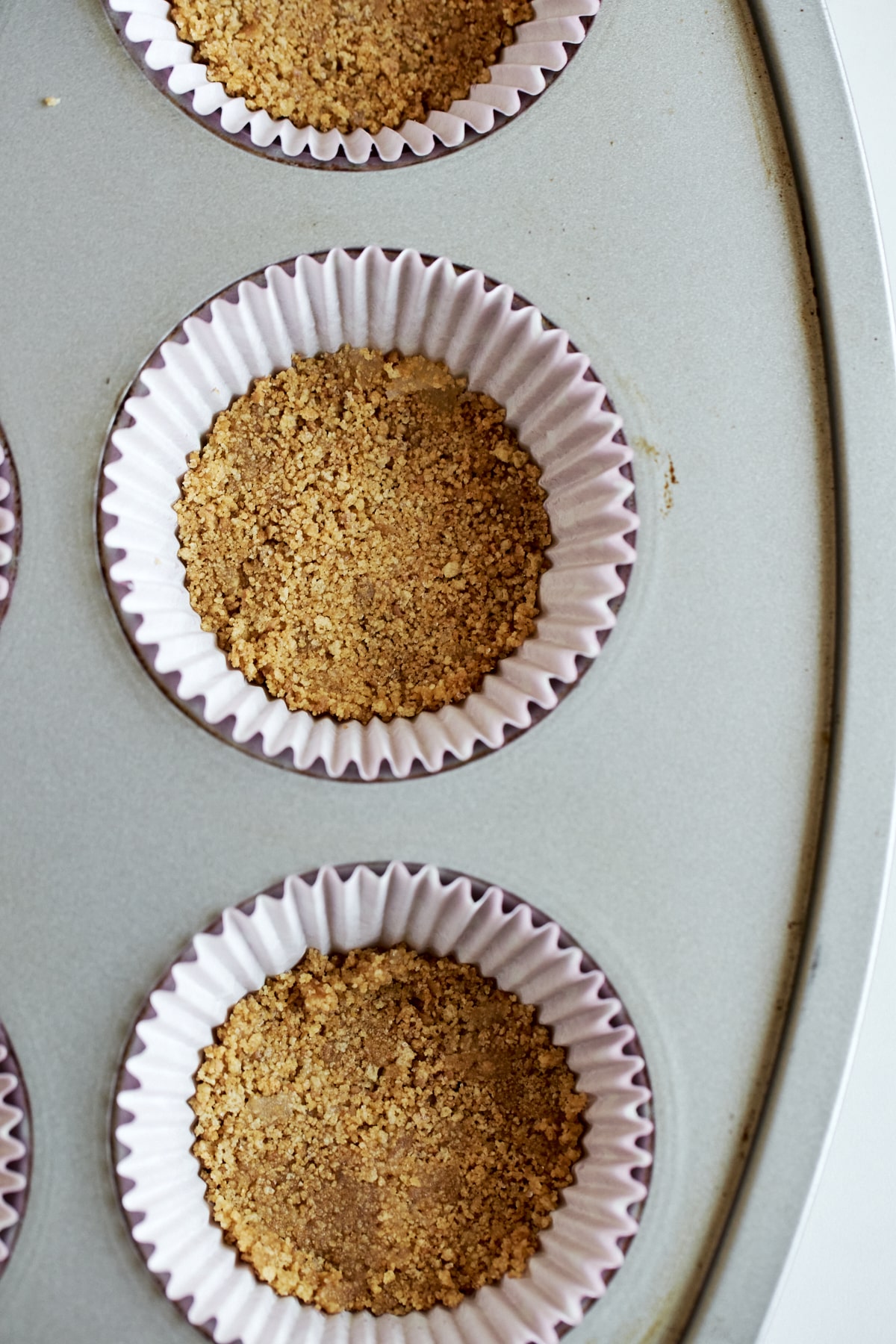 graham cracker crust pressed into cupcake liner