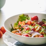 Quinoa topped with sweet red cherries, red onion, cashews and microgreens