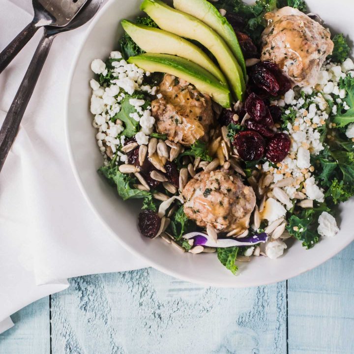 Kale salad greens topped with turkey meatballs, goat cheese and avocado