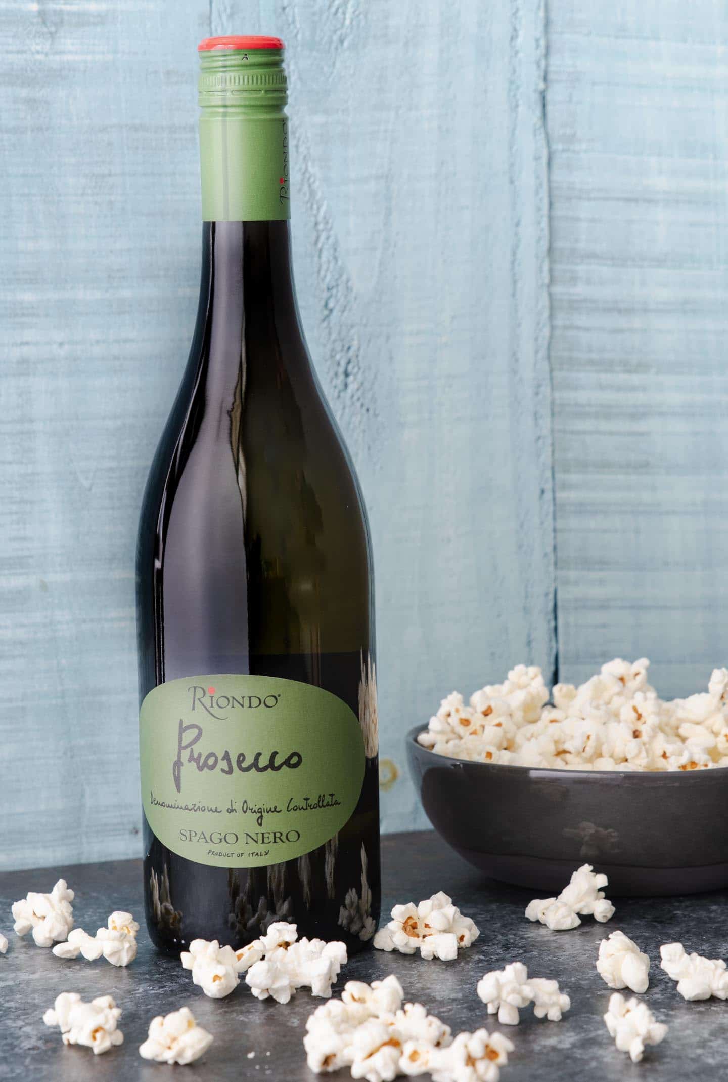 Riondo prosecco bottle with popcorn bowl and scattered popcorn