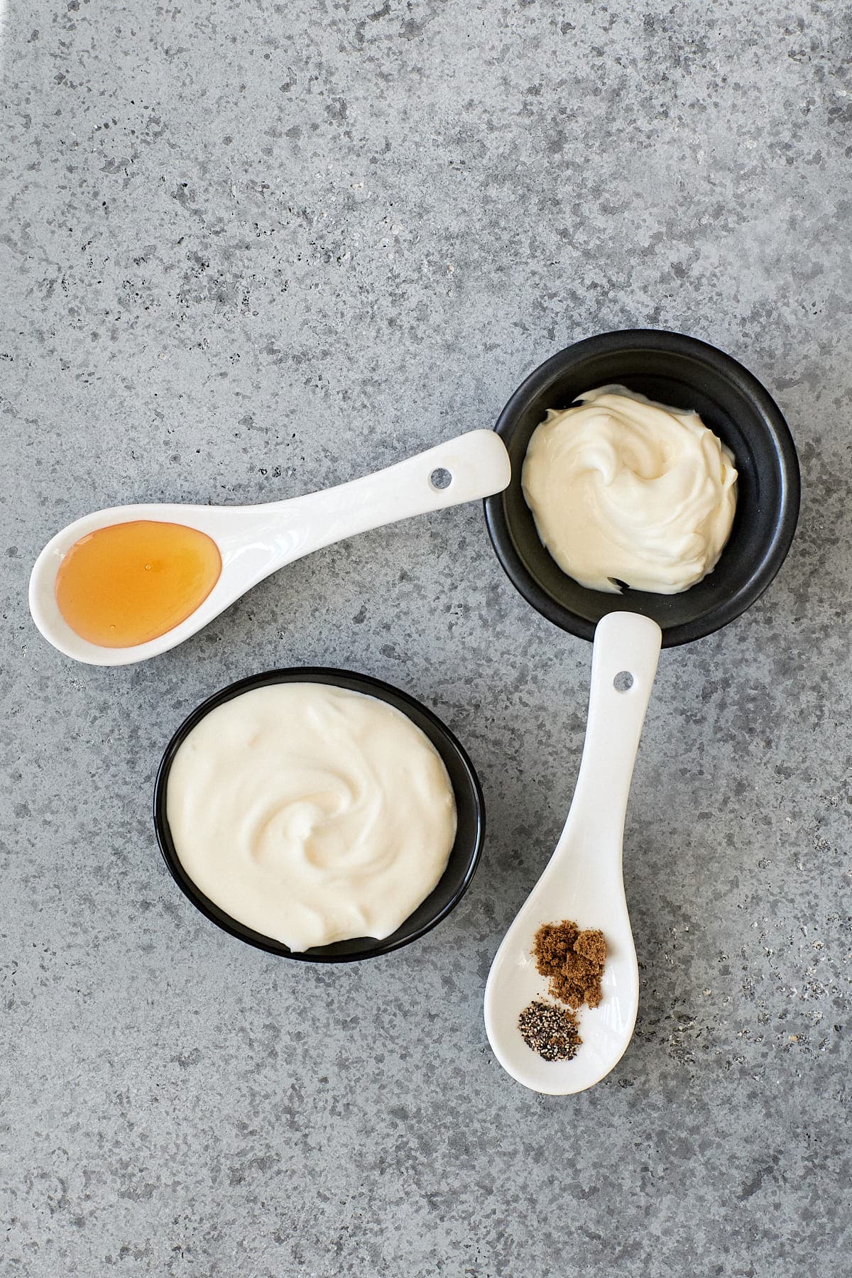 Dipping sauce ingredients | Creme fraiche and mascarpone in small bowls with spoons of honey, pepper and cumin