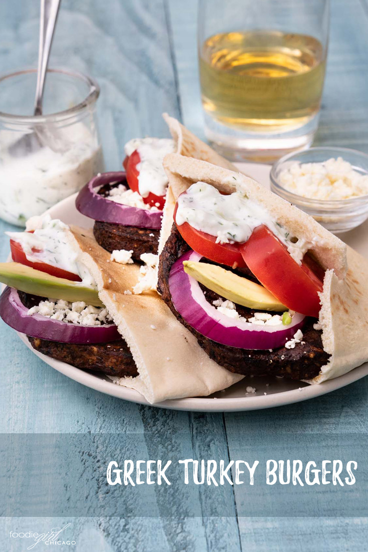 Three veggie burgers in pita pockets with Greek-inspired toppings