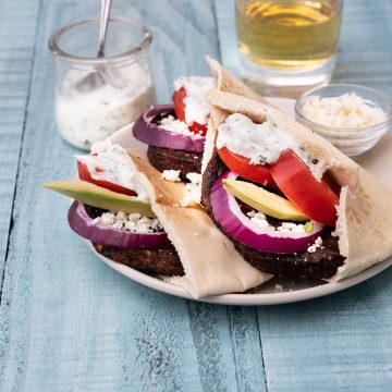 Three veggie burgers with Greek-inspired toppings