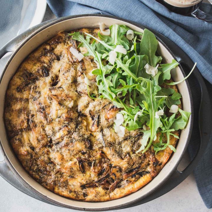 Caramelized onion frittata in a grey cast iron pan