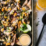Wonton chips topped with beef and beer cheese sauce on a baking sheet