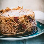 Spaghetti pie from a side angle on a teal plate