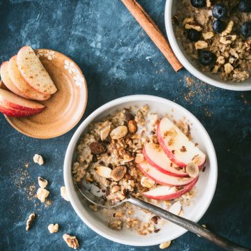 Instant Pot steel cut oats topped with apple slices, nuts and maple syrup