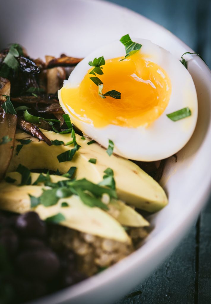 Close up of jammy egg on a quinoa breakfast bowl