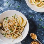 Bucatini in a cream bowl topped with crunchy bread crumbs and a cream lemon sauce