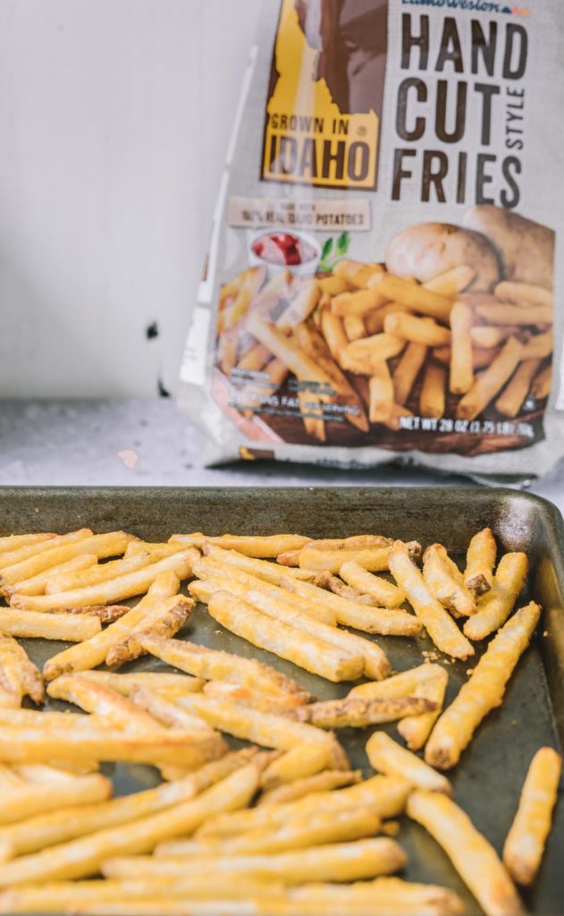 Close up of oven baked french fries with Grown In Idaho hand cut fries bag in the background