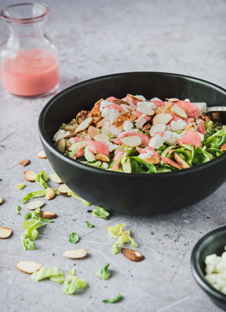 Quinoa topped with grilled chicken, goat cheese and bright raspberry dressing