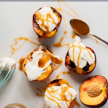 Four grilled peach halves topped with mascarpone and drizzled with caramel sauce