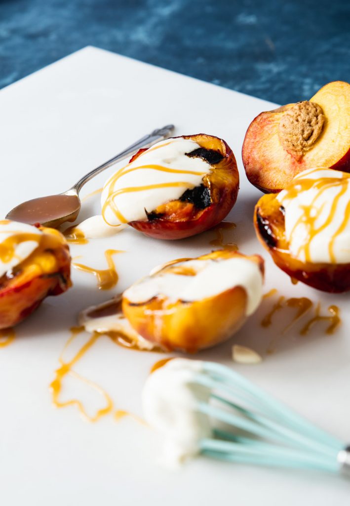 Grilled peach halves topped with mascarpone and caramel sauce